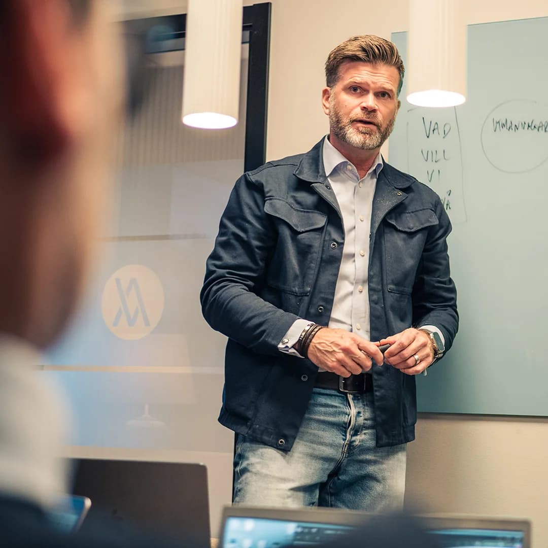 En rådgivare går igenom en plan vid whiteboarden