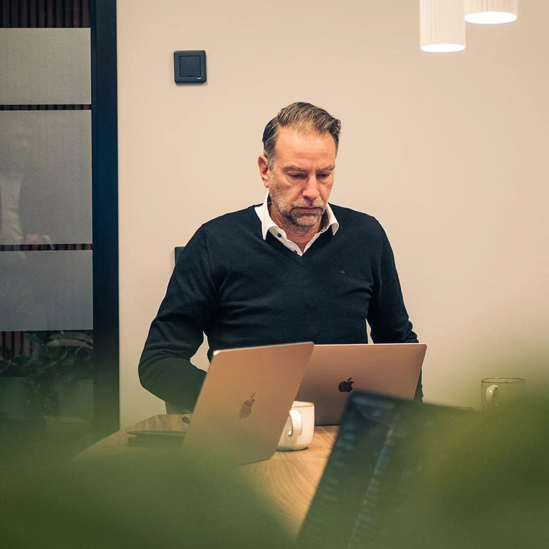En man arbetar vid sin dator på kontoret